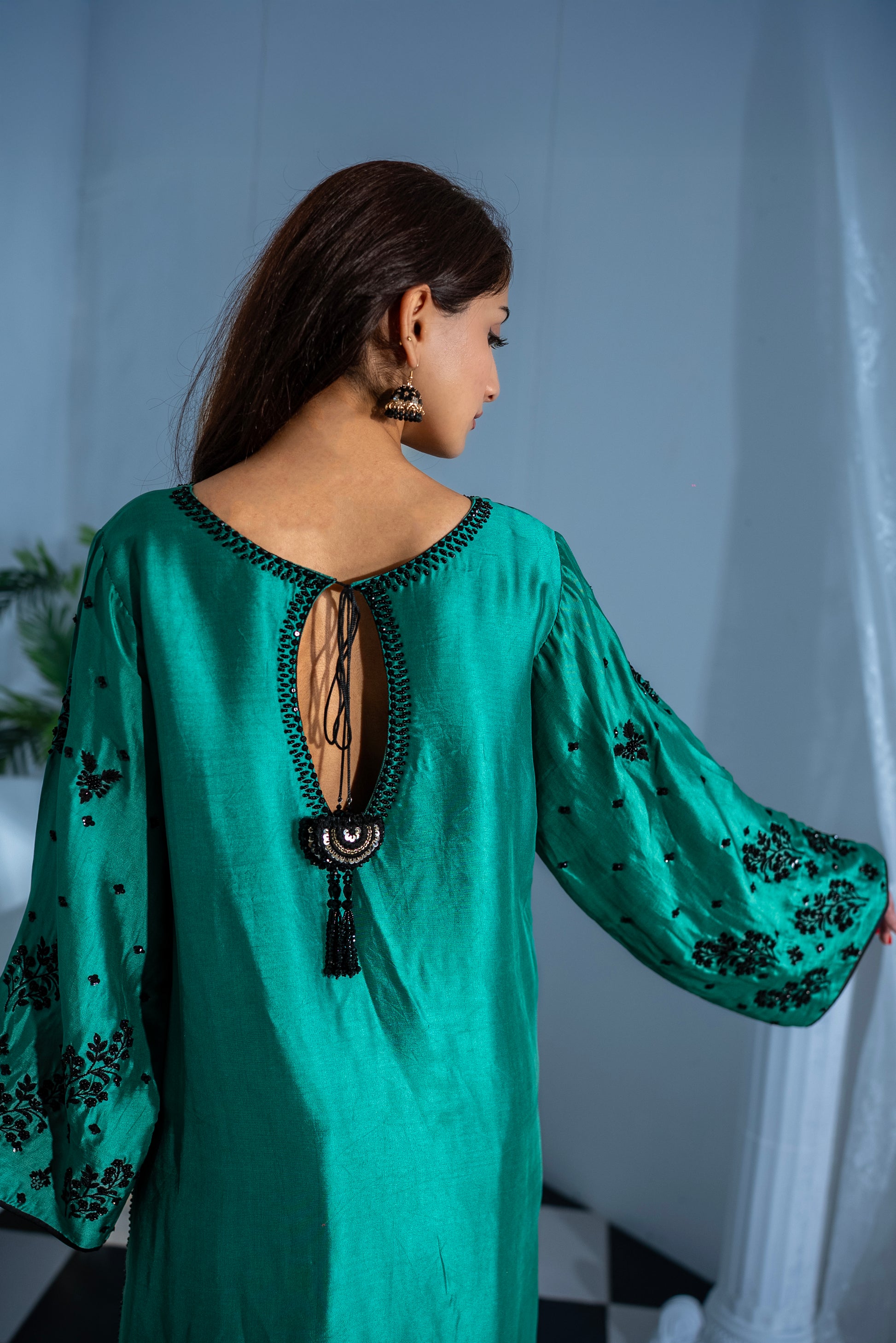 Back view of Jade Pakistani suit showing graceful keyhole tie accent and hand embroidery, raw silk trousers