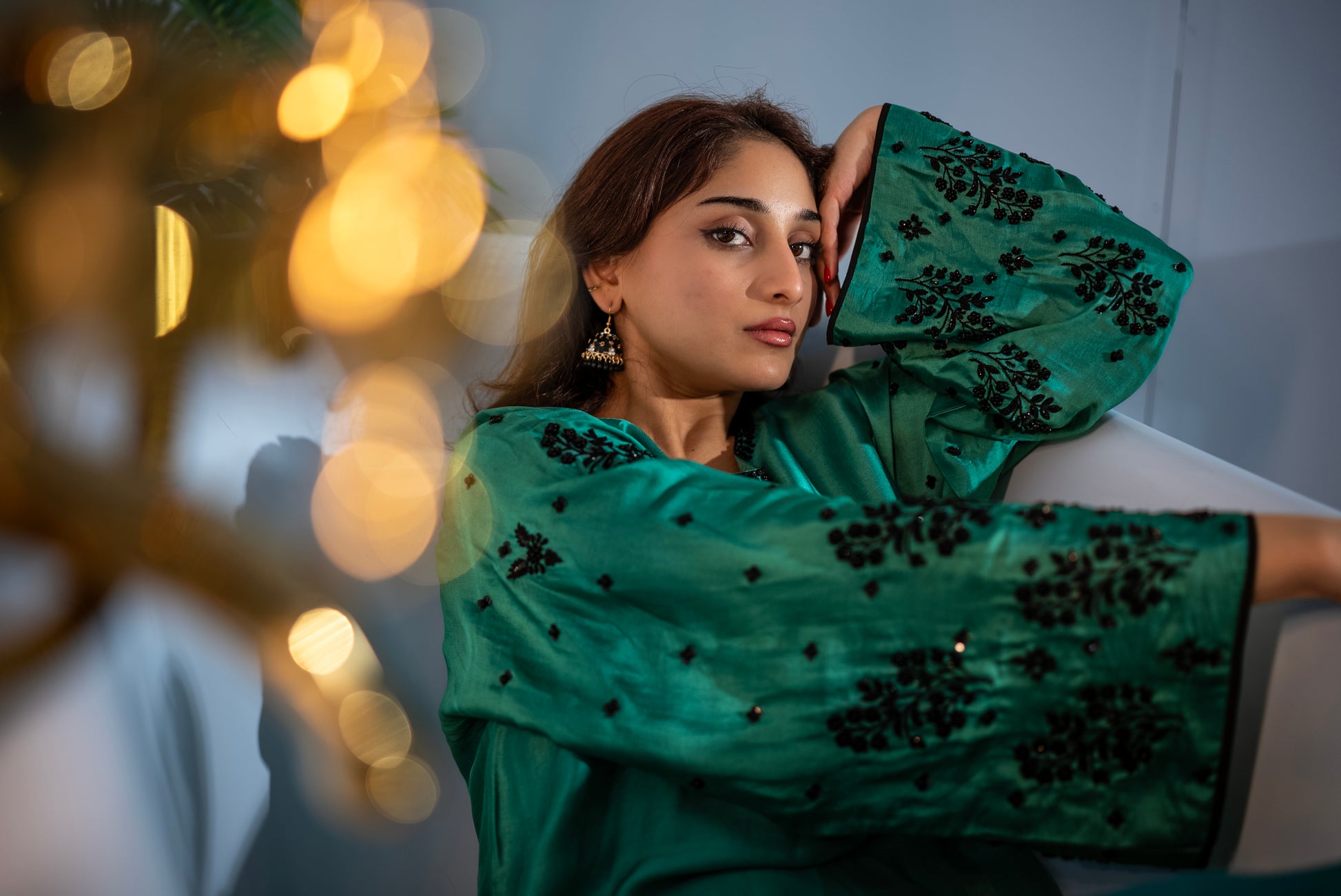 Woman wearing Jade green raw silk Pakistani designer suit with fluid drape, luxury formal wear UAE