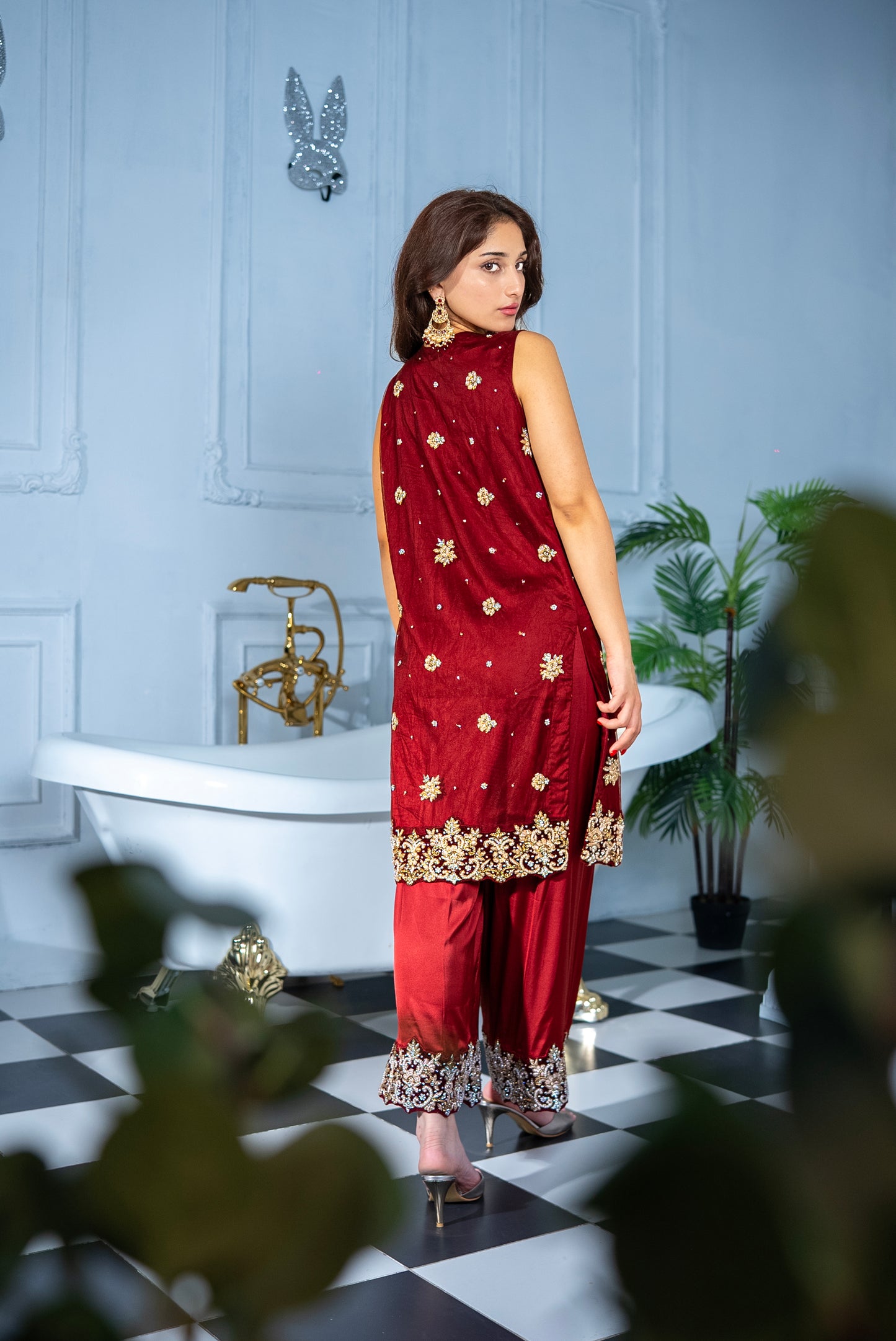 Woman wearing Veloura maroon khaddi net suit, luxury Pakistani wear UAE