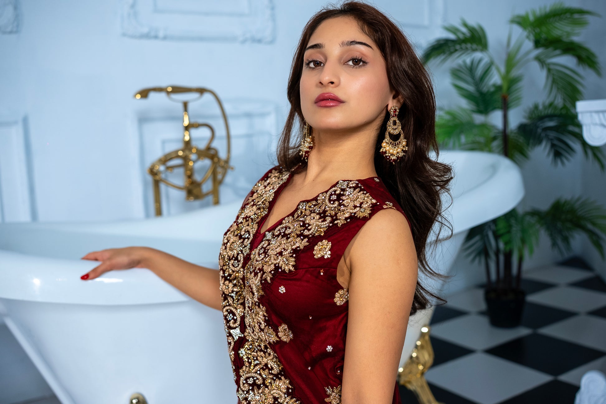 Close-up of Veloura maroon khaddi net suit gold embroidery detailing