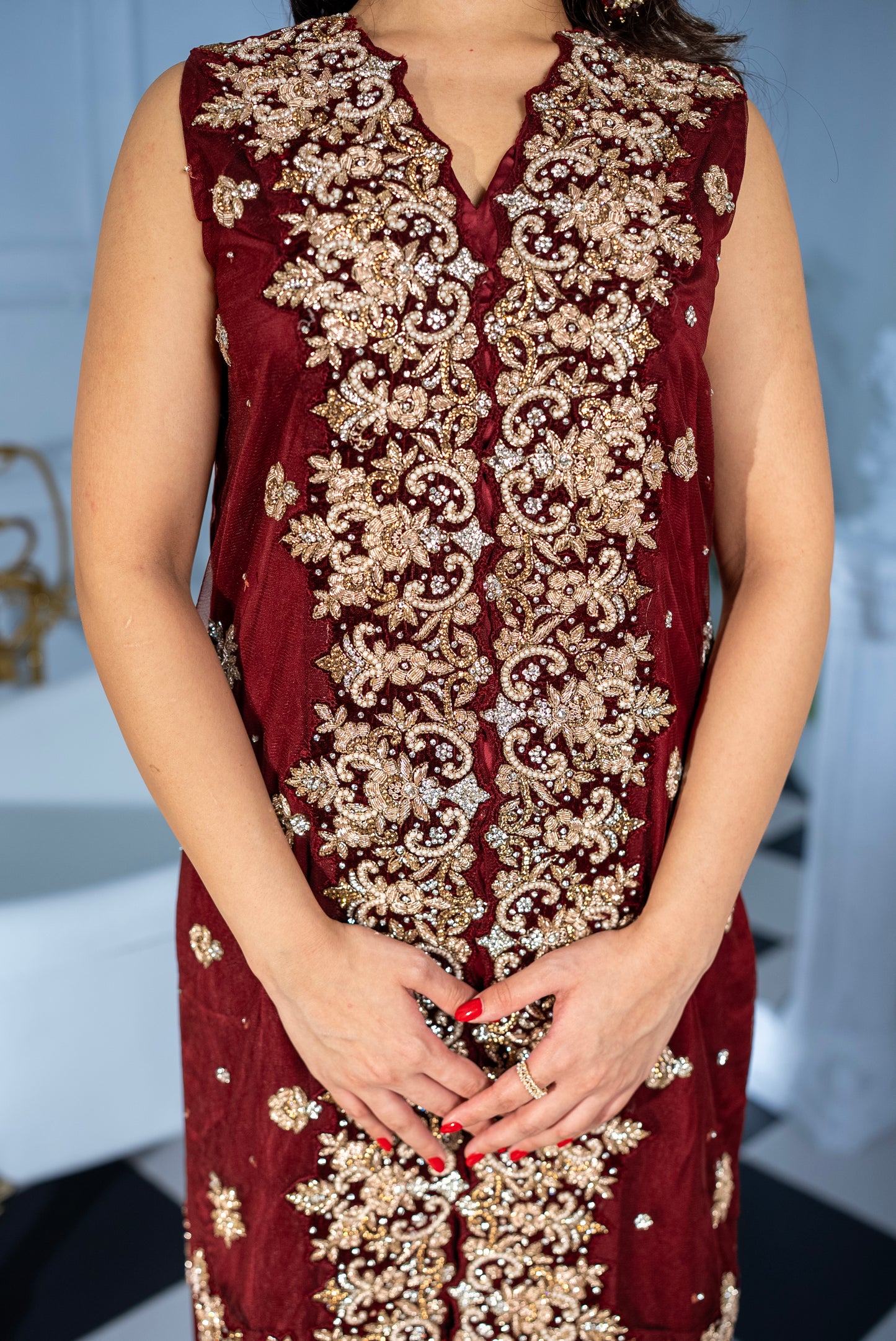 Woman wearing Veloura maroon khaddi net suit, luxury Pakistani wear UAE